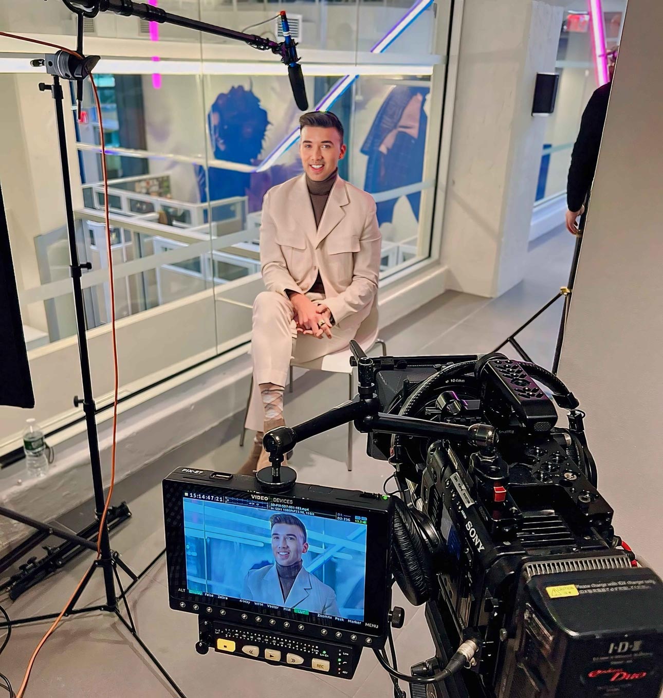 Dennis Kenney in a modern office building in front of a television interview video camera